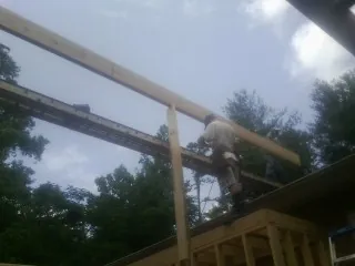 Carpenter setting a ridge beam over a new addition frame — Ice Dam Removal by Roofing Brothers in Fontanelle