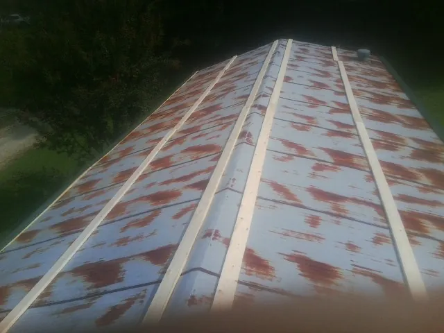 Rusted metal roof panels with new wood purlins before replacement — Storm Damage Roof Repair in Fontanelle by Roofing Brothers