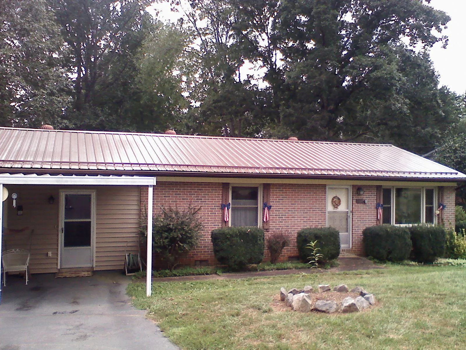Bronze metal roof and carport on a brick ranch home — Roof Repair work by our crew in Fontanelle